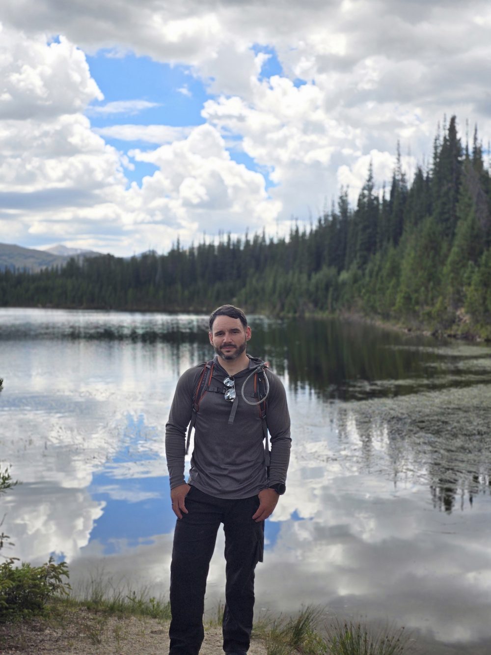 Ty standing by a mountain lake in Colorado